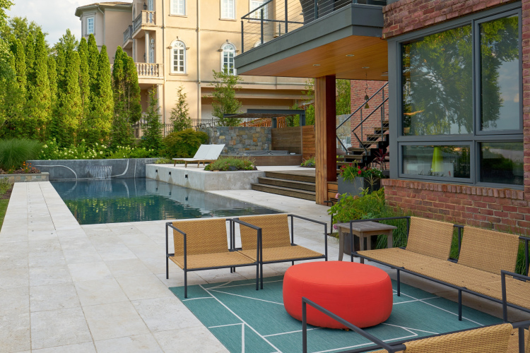 Outdoor seating area in Alexandria, overlooking the pool and landscaped surroundings.