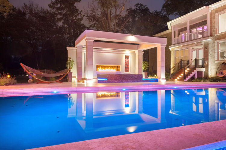 Custom pool with custom landscape lighting in McLean