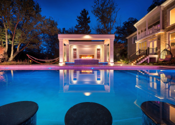 Night view of expansive pool patio with multiple seating areas