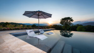 pool and patio oasis with sun umbrella and chaises